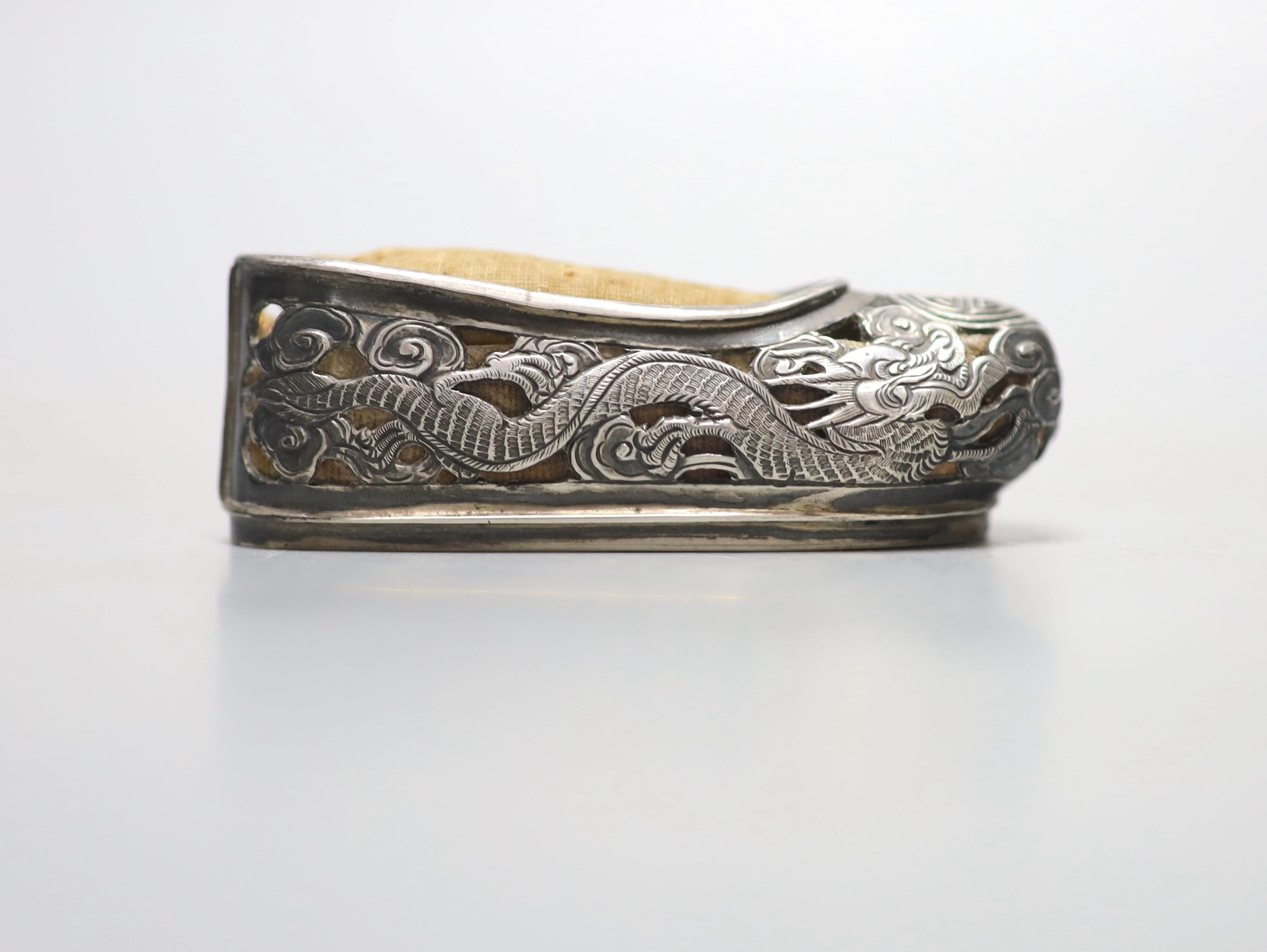 An early 20th century Chinese pierced white metal pin cushion, modelled as a shoe, maker KW, 81mm.